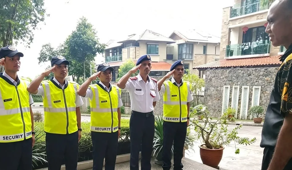 Five guards saluting at the entrance of a residential estate